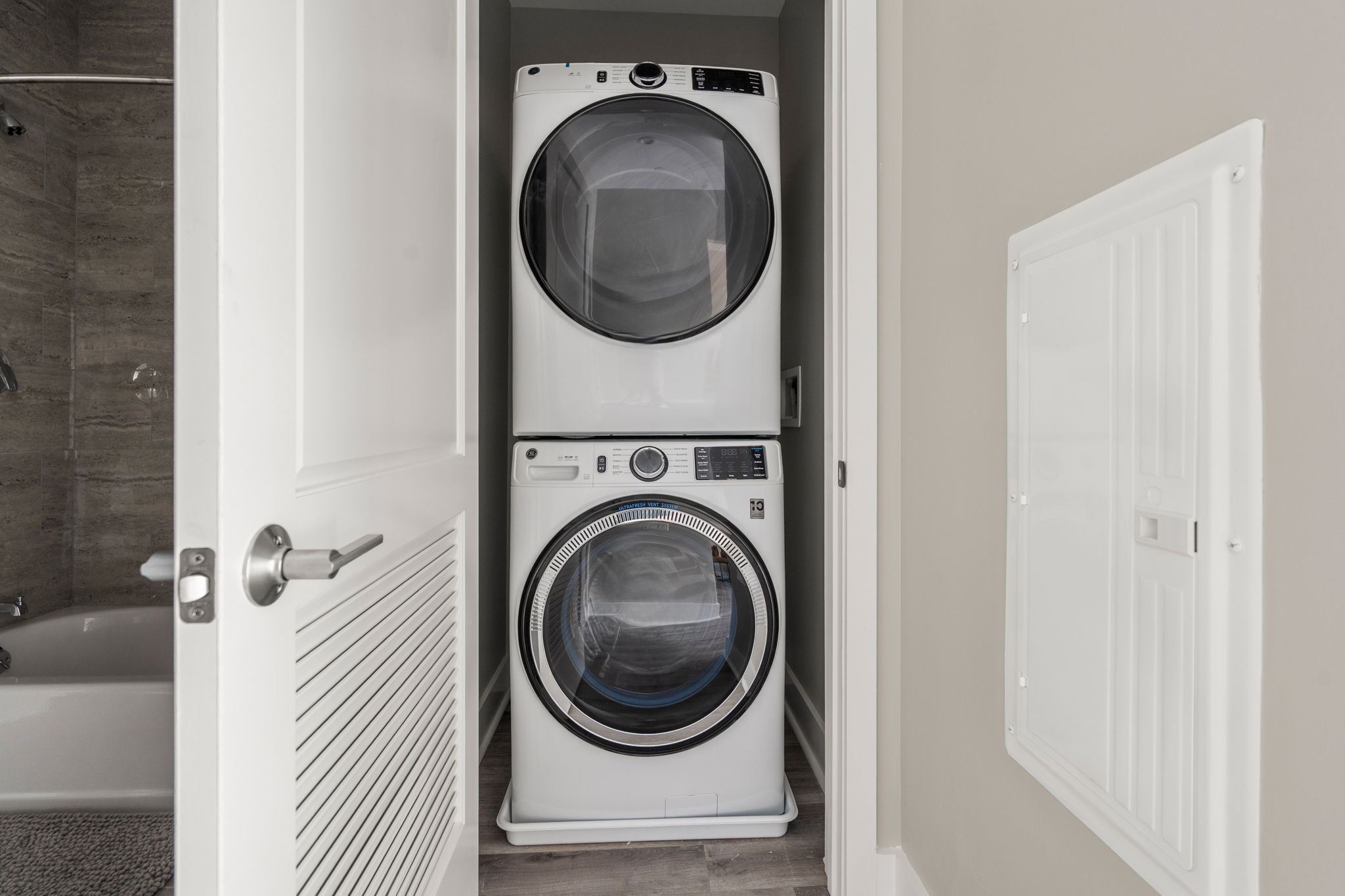 Dexter Street Commons, 1-Bed 2026-06-16 Stacked white front-loading washer and dryer in a laundry closet with doors open.